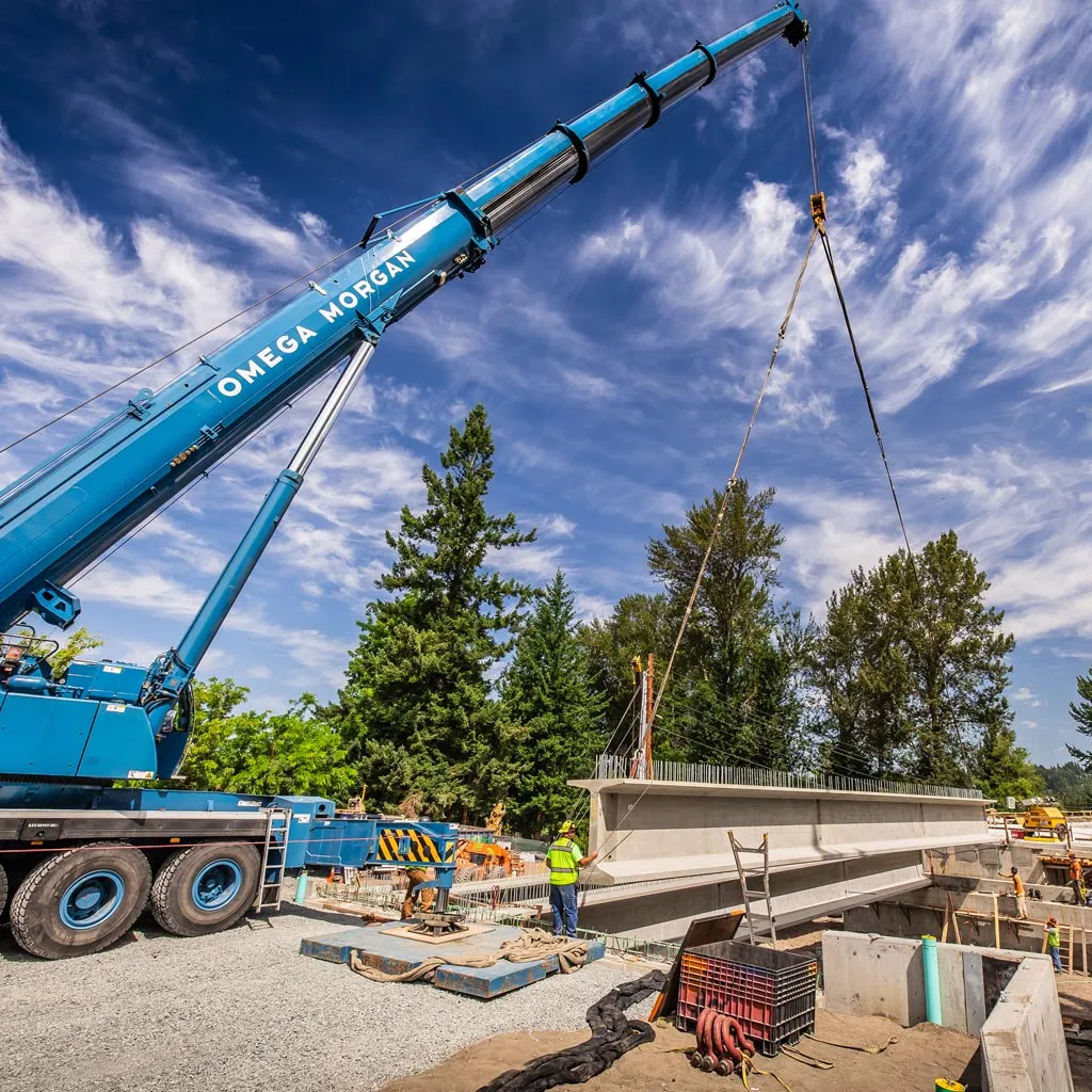 Omega Morgan crane service lifting a concrete bridge girder into place