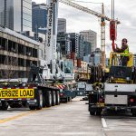 An Omega Morgan crane crew prepares the Tadano crane hook to lift a totem pole.