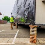 An Omega Morgan crane services crew member inspects the modular building before it’s moved.