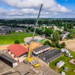 An overhead view of Omega Morgan’s 350-ton crane placing a modular classroom unit in place