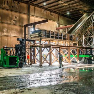The machinery moving team lines up three Telehandler All-Terrain Forklifts to prepare the move of a flight conveyor.