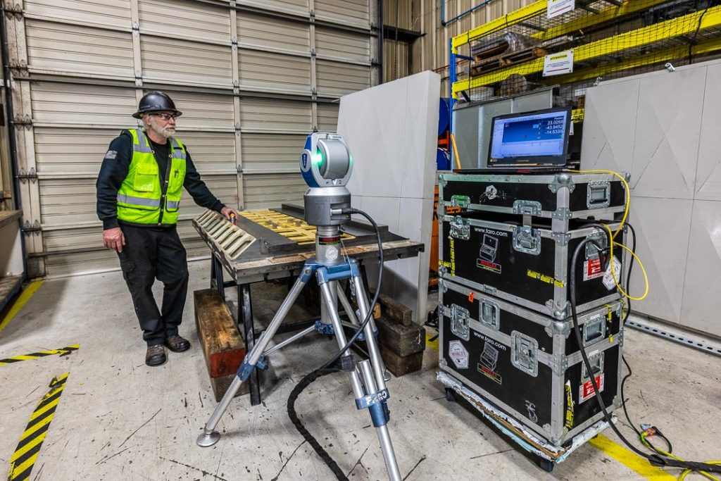 Metrology team member inspecting table dimensions with the laser tracker for table stack height and further machining.