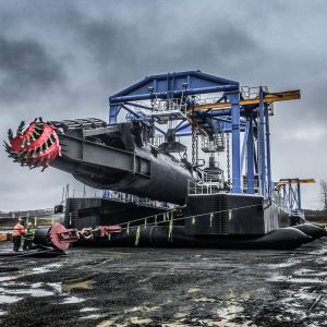 an enormous suction dredge in a rockpit being moved by Omega Morgan Millwright team