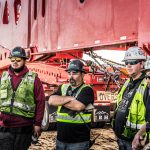 Crew members standing together in front of a 500-ton suspension trailer.