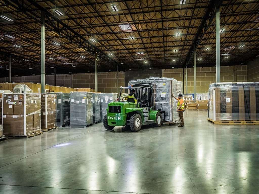 inside the Omega Morgan Hillsboro warehouse where a forklift with a large load is being brought in