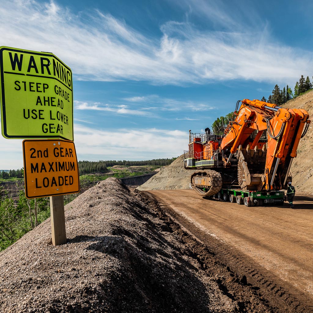 Omega Morgan’s heavy haul trucking equipment transports a 600,000-pound mining shovel up a steep grade.