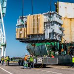 A 299,829-pound transformer being lowered from a shipping vessel onto our trailer and being received by the Omega Morgan specialized transportation crew.