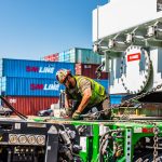 A crew member secures a transformer to the trailer before transport.