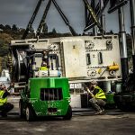 Omega Morgan crews using tandem trilifters and forklift to move a 140,000 pound aluminum can press