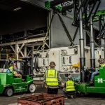 Omega Morgan crew moving a 140,000 pound aluminum can press into storage with tandem trilifters
